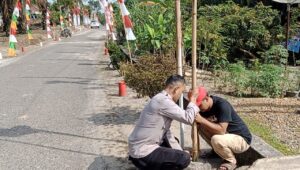 Bhabinkamtibmas Ajak Warga Desa Muara Harapan Semarakkan Kemerdekaan dengan Memasang Bendera Merah Putih