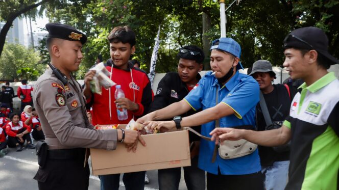 
					Di Tengah Terik Aksi, Petugas Kepolisian Turun Bagikan Air Mineral dan Roti ke Pengunjuk Rasa