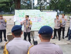 Polisi Bagikan Air Mineral dan Roti kepada Massa Aksi Damai Guru di Silang Selatan Monas
