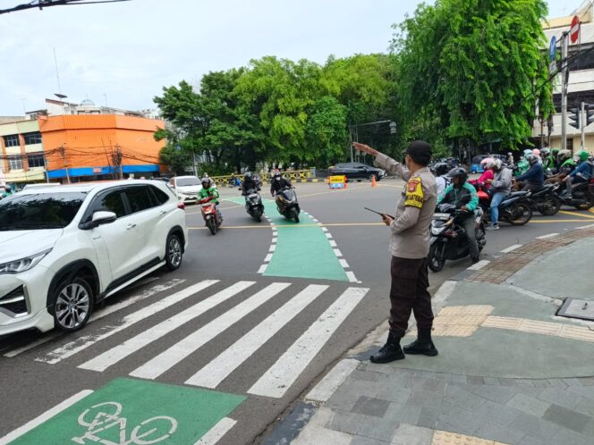 
					Bhabinkamtibmas Petojo Selatan Atur Lalu Lintas Pagi Hari di TL Caringin, Wujud Pelayanan Humanis Polri