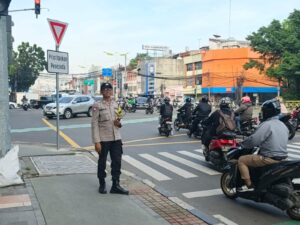 Bripka Salam NZ Lakukan Pengaturan Lalu Lintas Pagi di TL Caringin Petojo Selatan