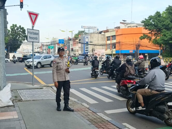 
					Bripka Salam NZ Lakukan Pengaturan Lalu Lintas Pagi di TL Caringin Petojo Selatan