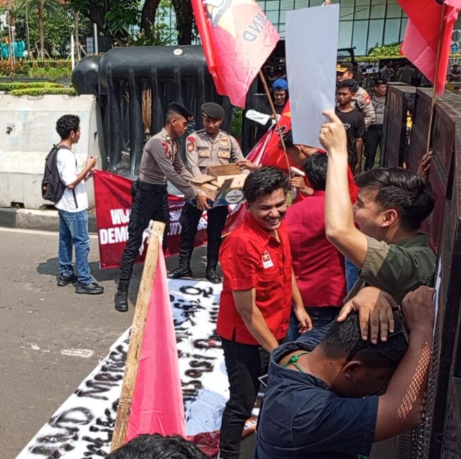 
					Di Tengah Aksi Penyampaian Aspirasi, Polisi Bagikan Air Mineral dan Snack untuk Massa
